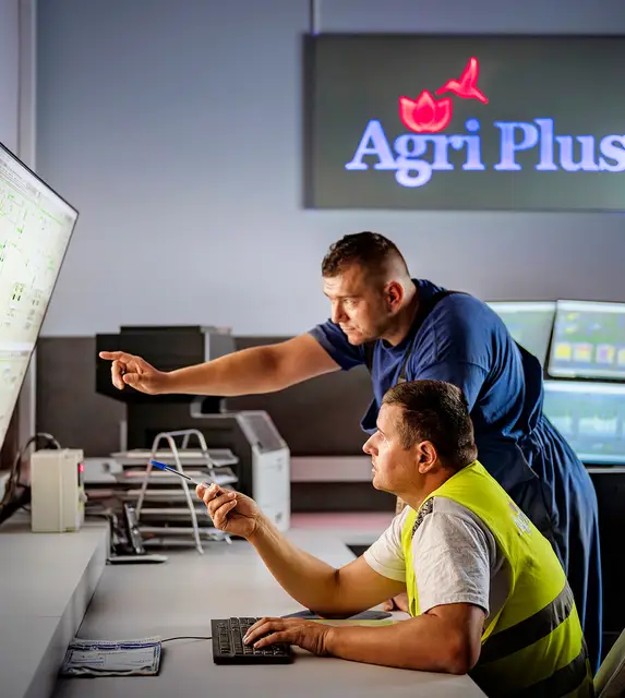 Two men in an office examining data on a screen